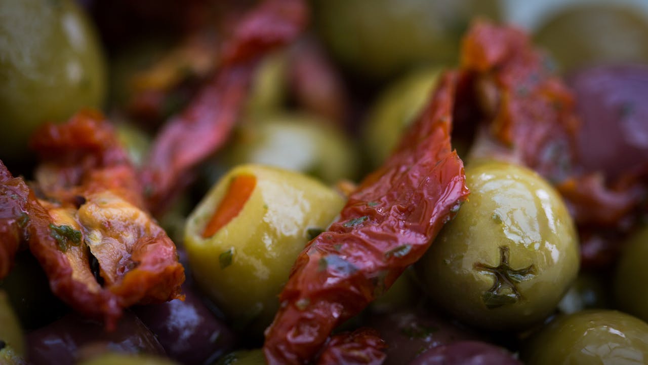 Vibrant marinated olives and sun-dried tomatoes in a savory setting.